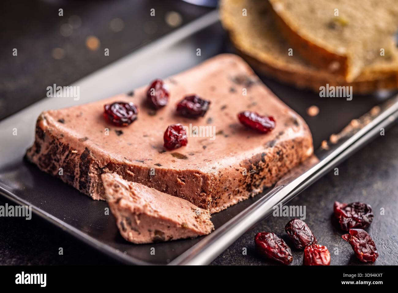 Pâté de foie avec des canneberges sur une plaque noire. Banque D'Images