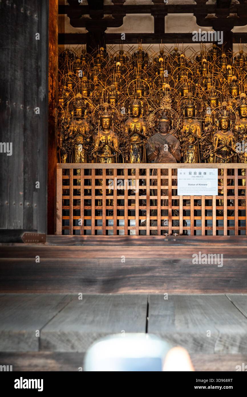 Statue de Kannara (Kinnara) – Déité musicienne mythique, avec Kannon des mille-armées en arrière-plan la nuit, Sanjusangendo Banque D'Images