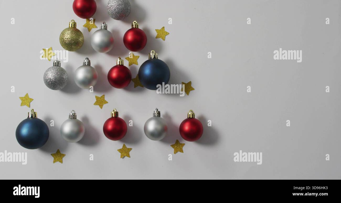 Affichant des boules triangulaires rouge argent bleu or avec des capuchons en métal sur le dessus de table blanc, espace copie Banque D'Images