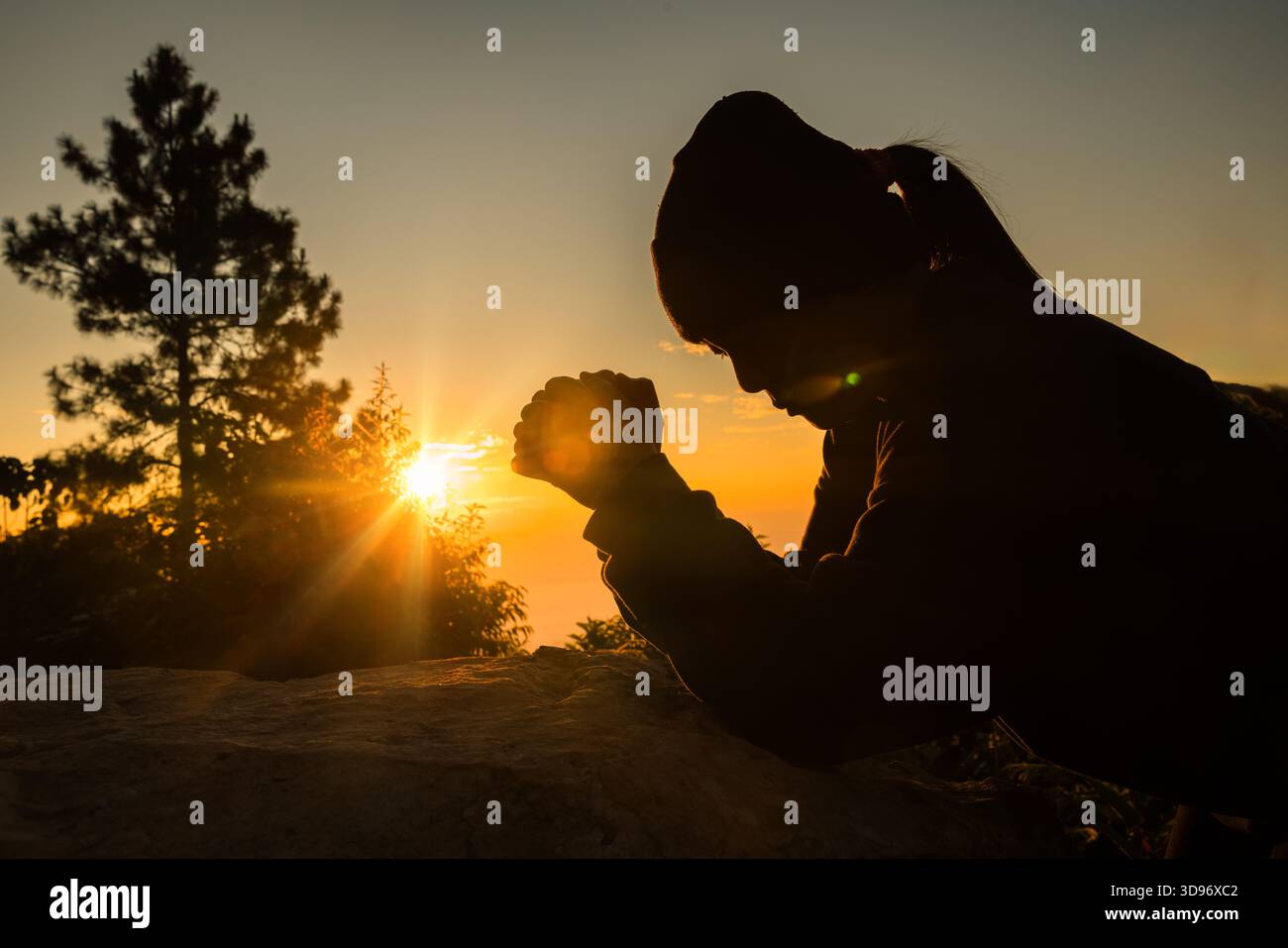 Silhouette de femme s'agenouillant en priant pour l'adoration de Dieu sur fond de ciel. Les chrétiens prient à jésus-christ pour le calme. "Le matin, les gens ont atteint un. Banque D'Images