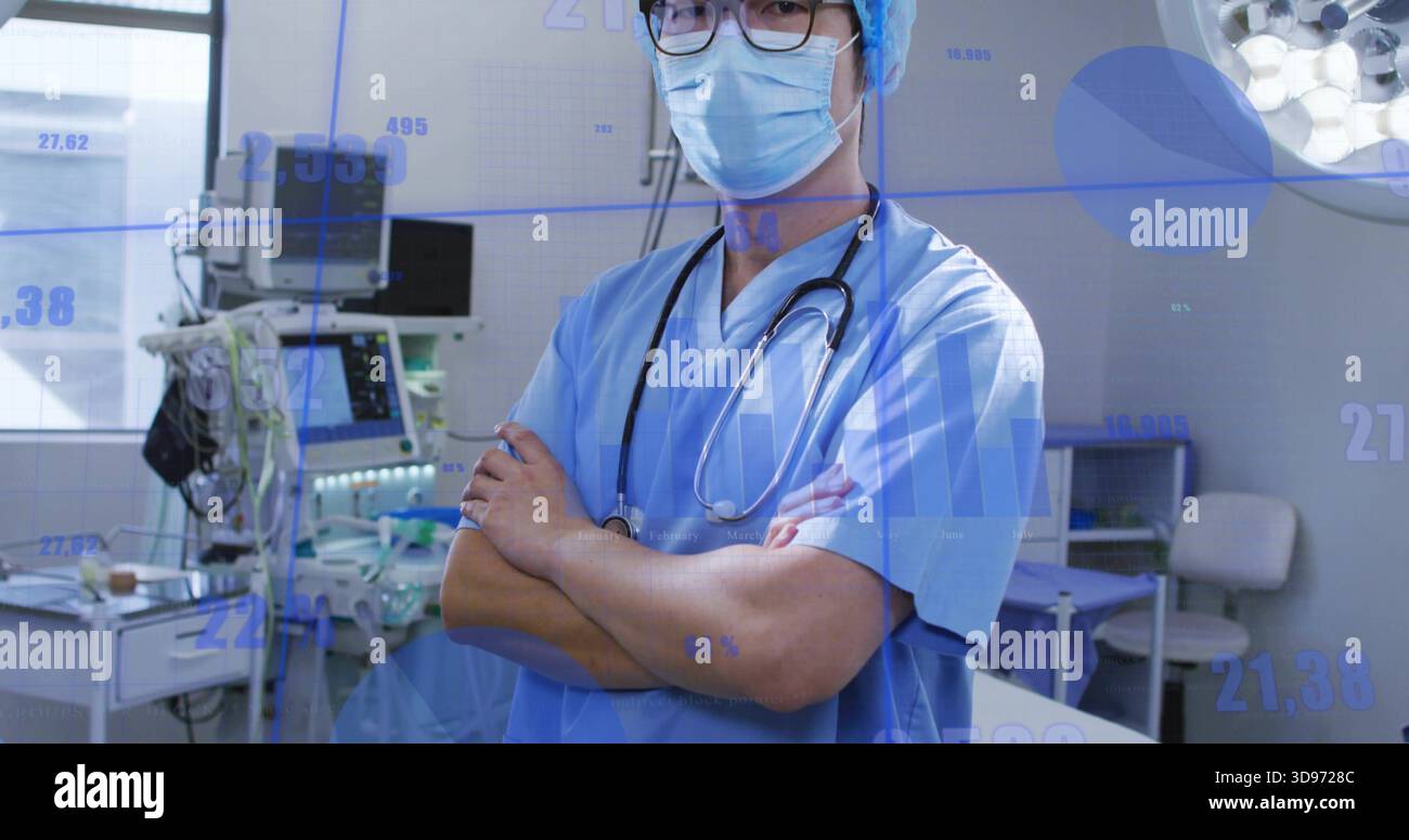 Médecin debout portant des gommages bleus avec stéthoscope dans la salle d'opération, avec moniteurs Banque D'Images