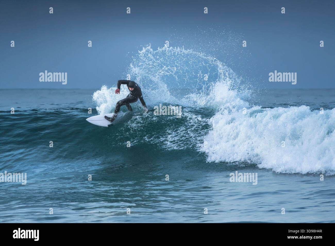 Un surfeur qui fait une vague à Fistral à Newquay, en Cornouailles, au Royaume-Uni. Banque D'Images