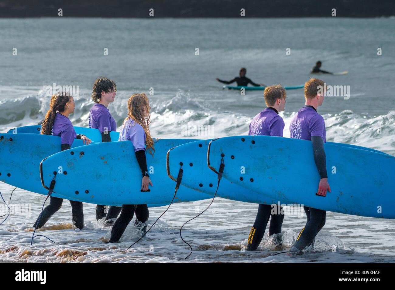 Surfeurs débutants apprenant à surfer avec l'école de surf Fistral Beach à Fistral à Newquay en Cornouailles au Royaume-Uni. Banque D'Images