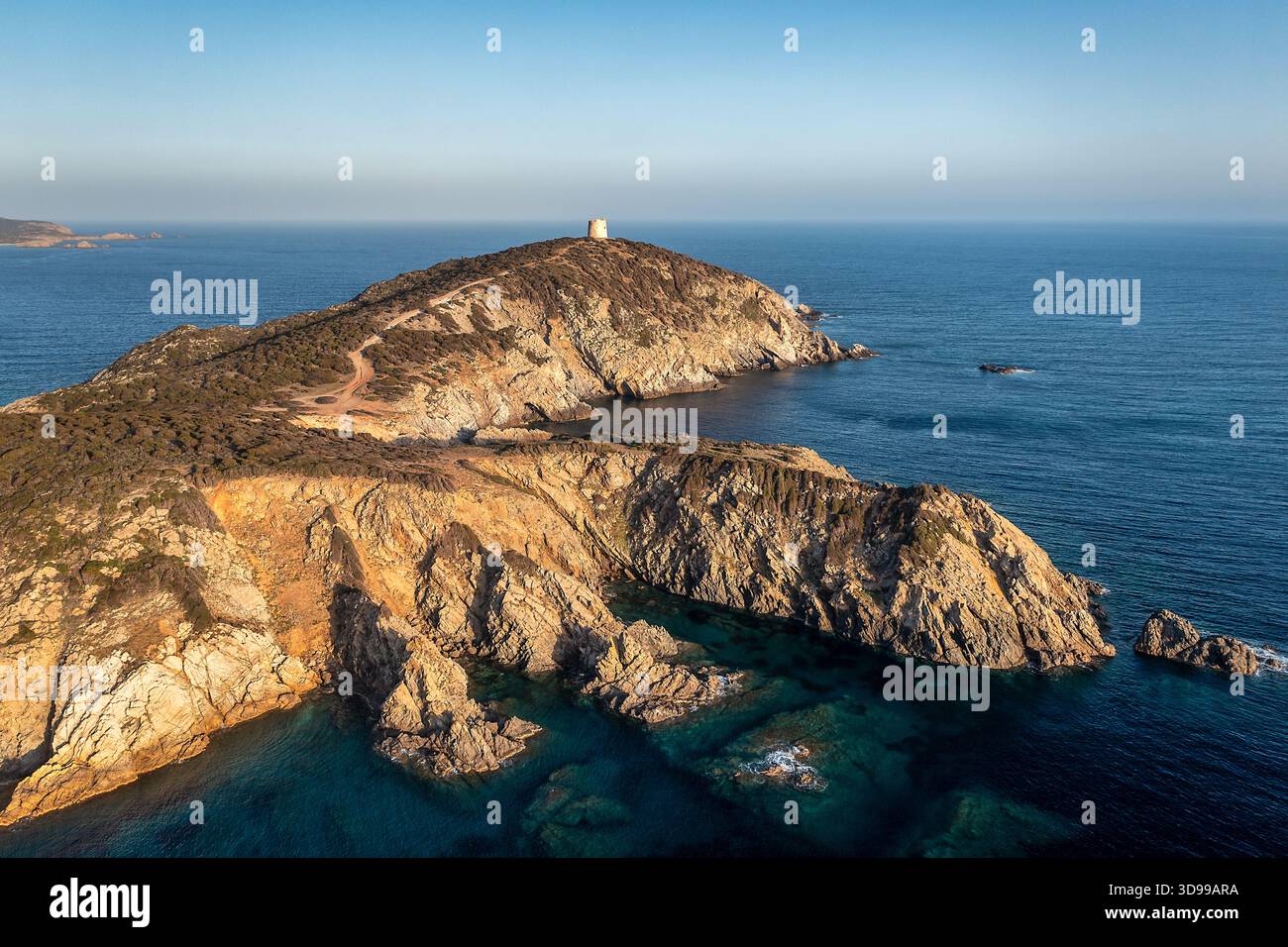 La côte sauvage de l'île dispose d'une petite tour au sommet d'une colline rocheuse, surplombant l'océan bleu calme, Sardaigne, Italie Banque D'Images