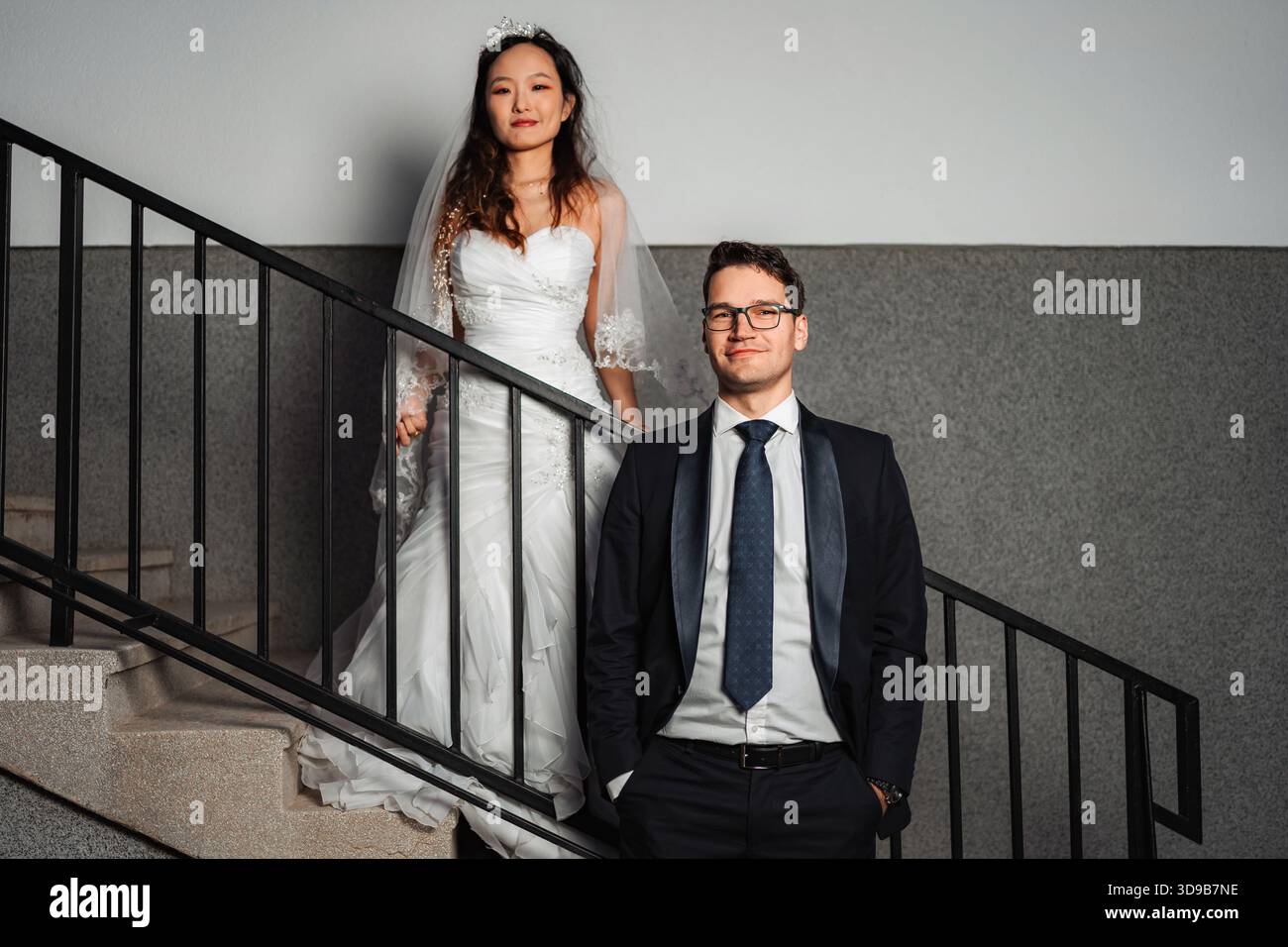 Couple de mariage interracial posant sur un escalier Banque D'Images