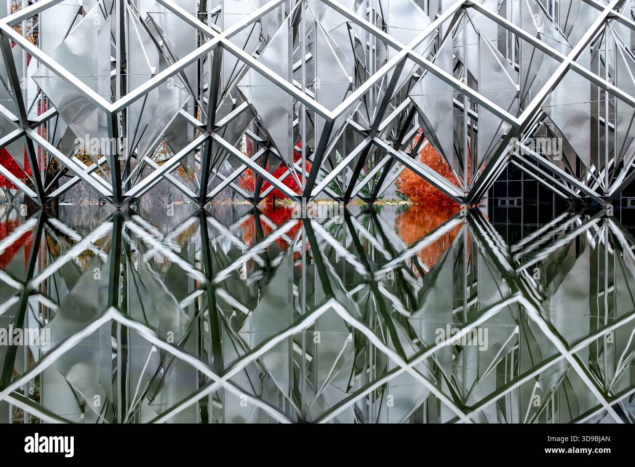 Delta Solar sculpture Smithsonian National Air and Space Museum Washington DC // WASHINGTON DC — Delta Solar est une sculpture cinétique en acier inoxydable de 27 pieds (8,23 m) de l'artiste vénézuélien Alejandro Otero, située dans une piscine réfléchissante du Musée national de l'Air et de l'espace. Dédiée le 29 juin 1977, comme cadeau du bicentenaire du Venezuela aux États-Unis, ses voiles rotatives symbolisent la technologie moderne et l'ancien culte du soleil inca. Le travail monumental pèse 6 895 kilogrammes (15 200 livres) et est un exemple significatif de diplomatie culturelle de la guerre froide. Il incarne la puissance douce du Venezuela pendant son oï Banque D'Images