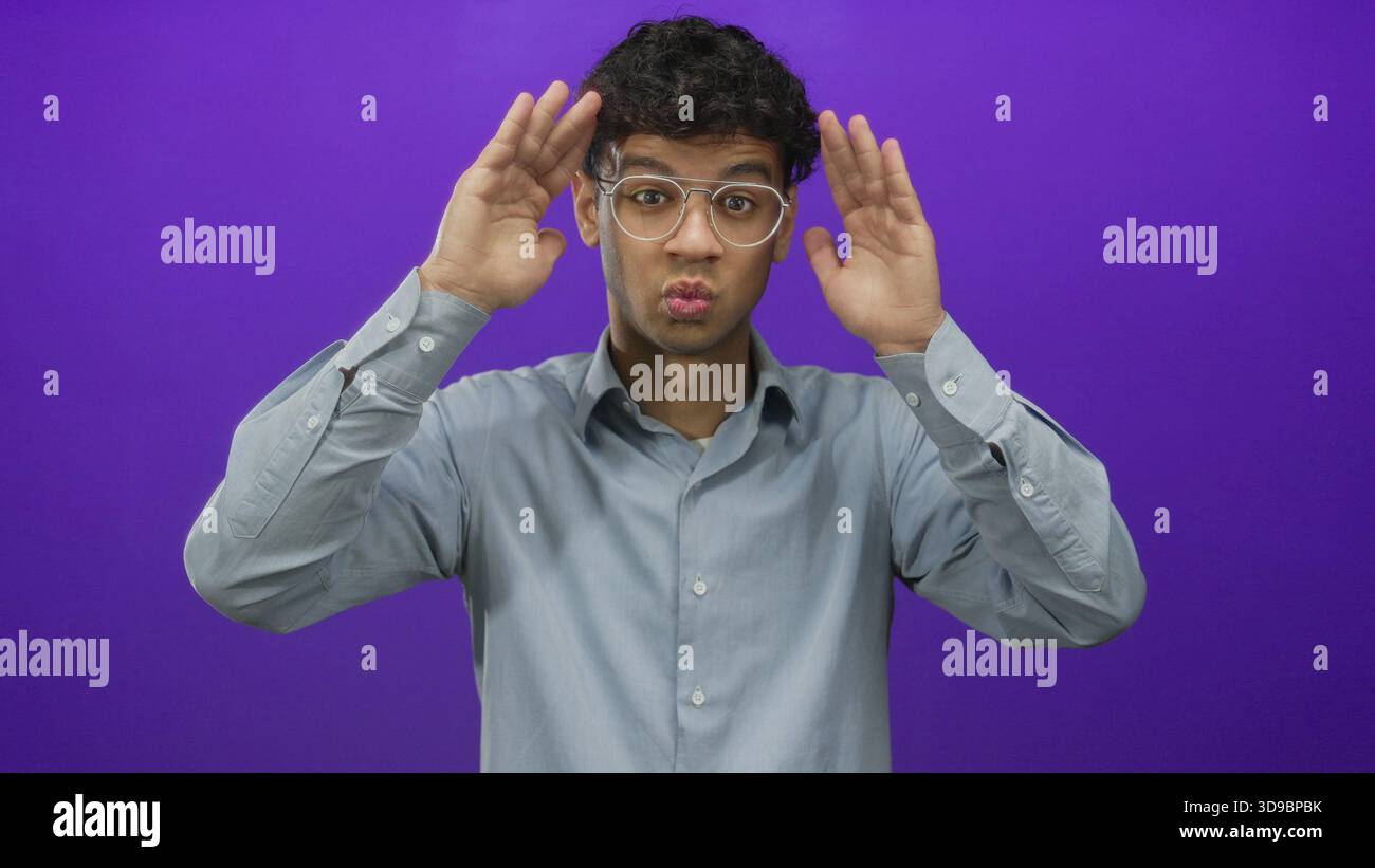 Jeune homme hispanique avec des lunettes couvre les yeux avec les mains ouvertes dans un cadre de studio violet ; intimité de timidité. Banque D'Images