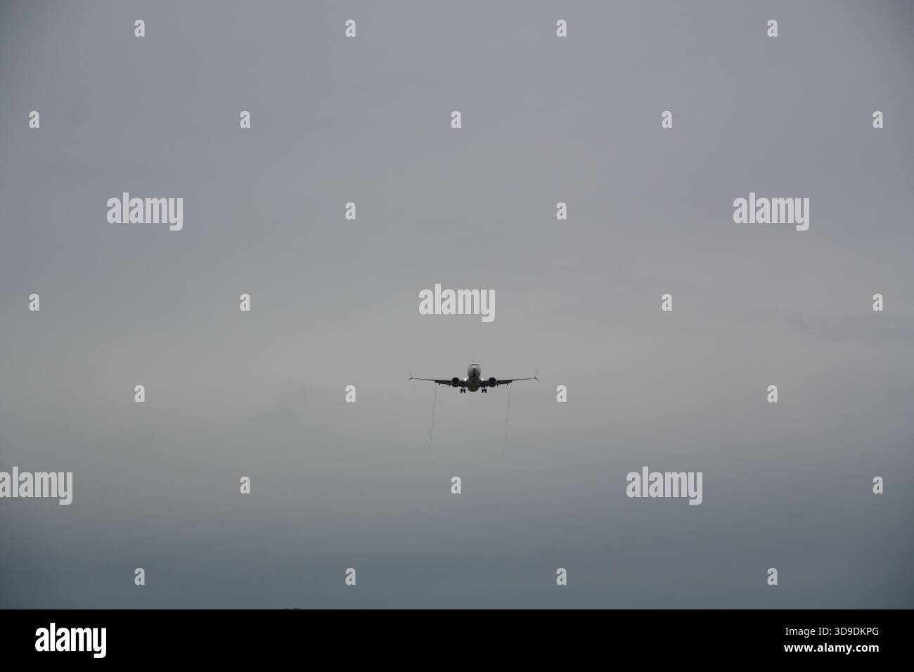 Avion commercial approchant pour atterrir par temps nuageux Banque D'Images