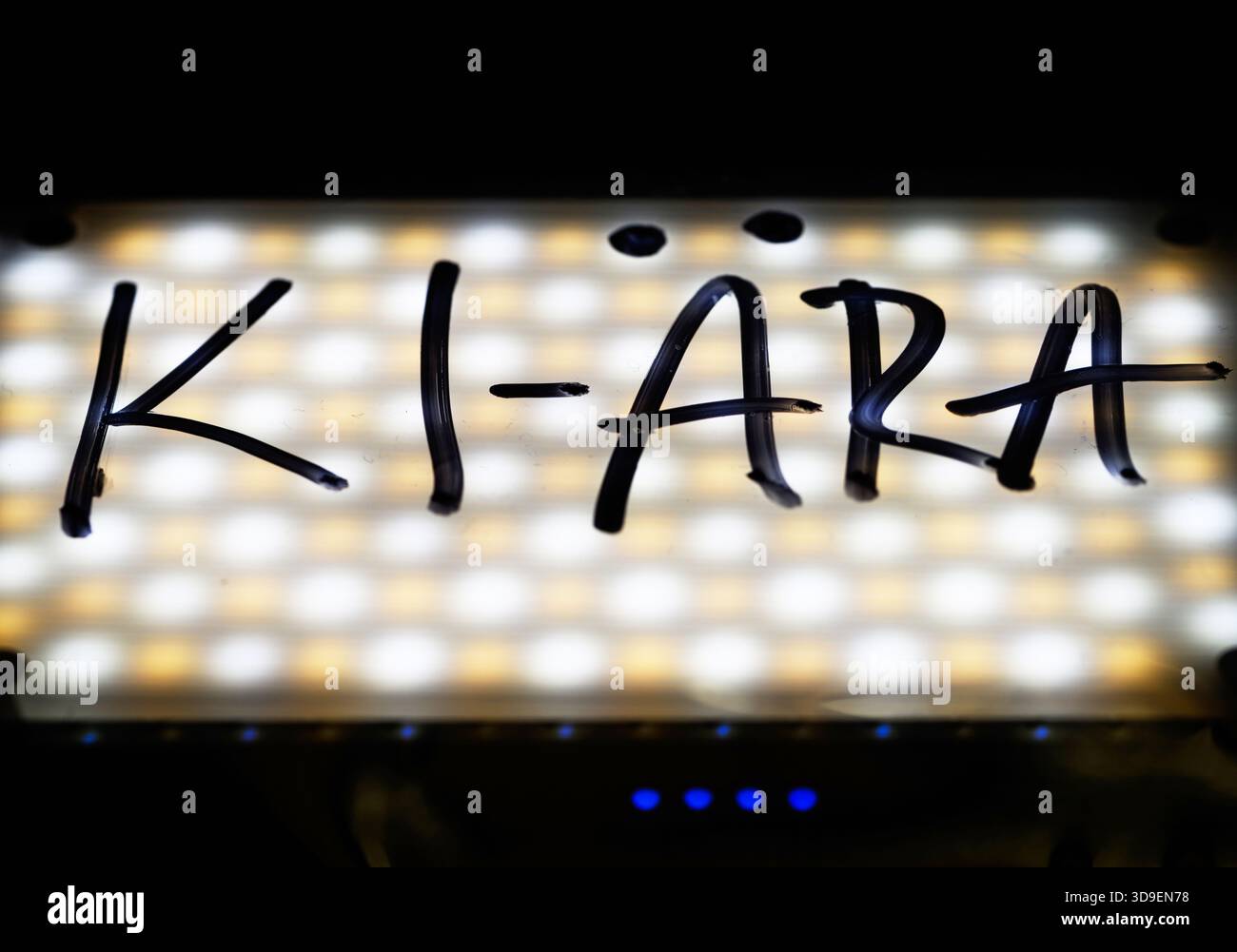 Dresde, Allemagne. 04th Dec, 2025. ILLUSTRATION - le mot « Ki-Ära » est écrit à la main sur une feuille devant une lampe LED. Le mot de l'année est 'Ki-Ära', comme annoncé par la Société de langue allemande (GfdS). Chaque année, un jury d’experts sélectionne une liste de mots qui ont frappé une corde linguistique au cours d’une année donnée. Crédit : Robert Michael/dpa/Alamy Live News Banque D'Images