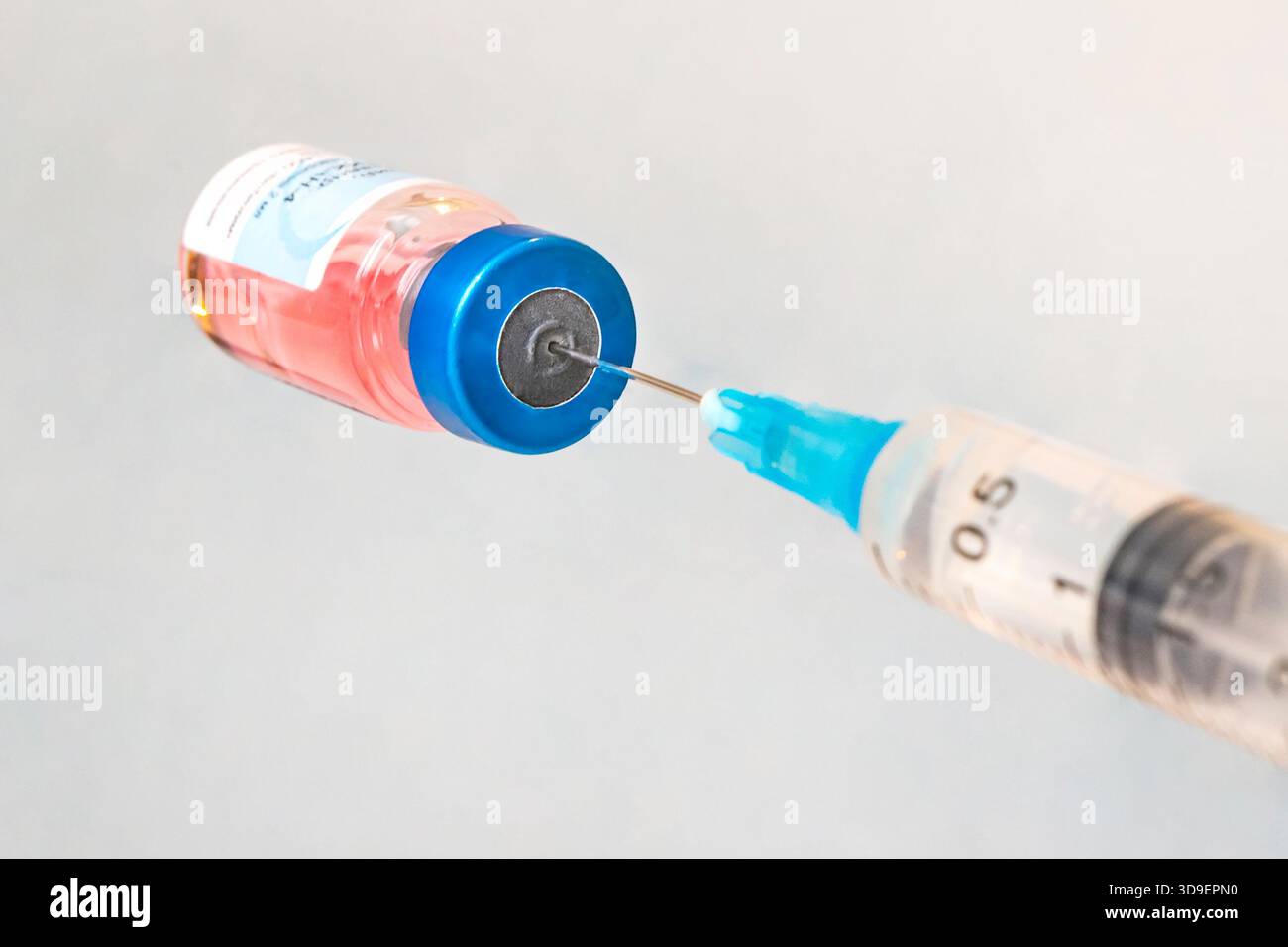 Vaccin en flacon avec seringue sur fond bleu Banque D'Images