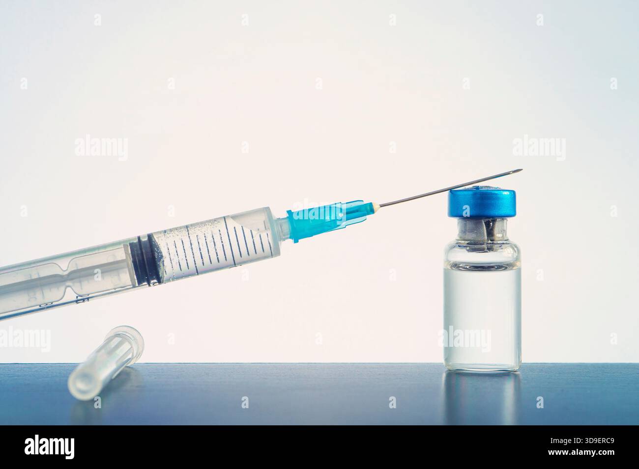 Un flacon en verre de liquide, un vaccin et une seringue médicale se rapprochent sur fond bleu. Le concept de vaccination contre le coronavirus . Bannière, cop Banque D'Images