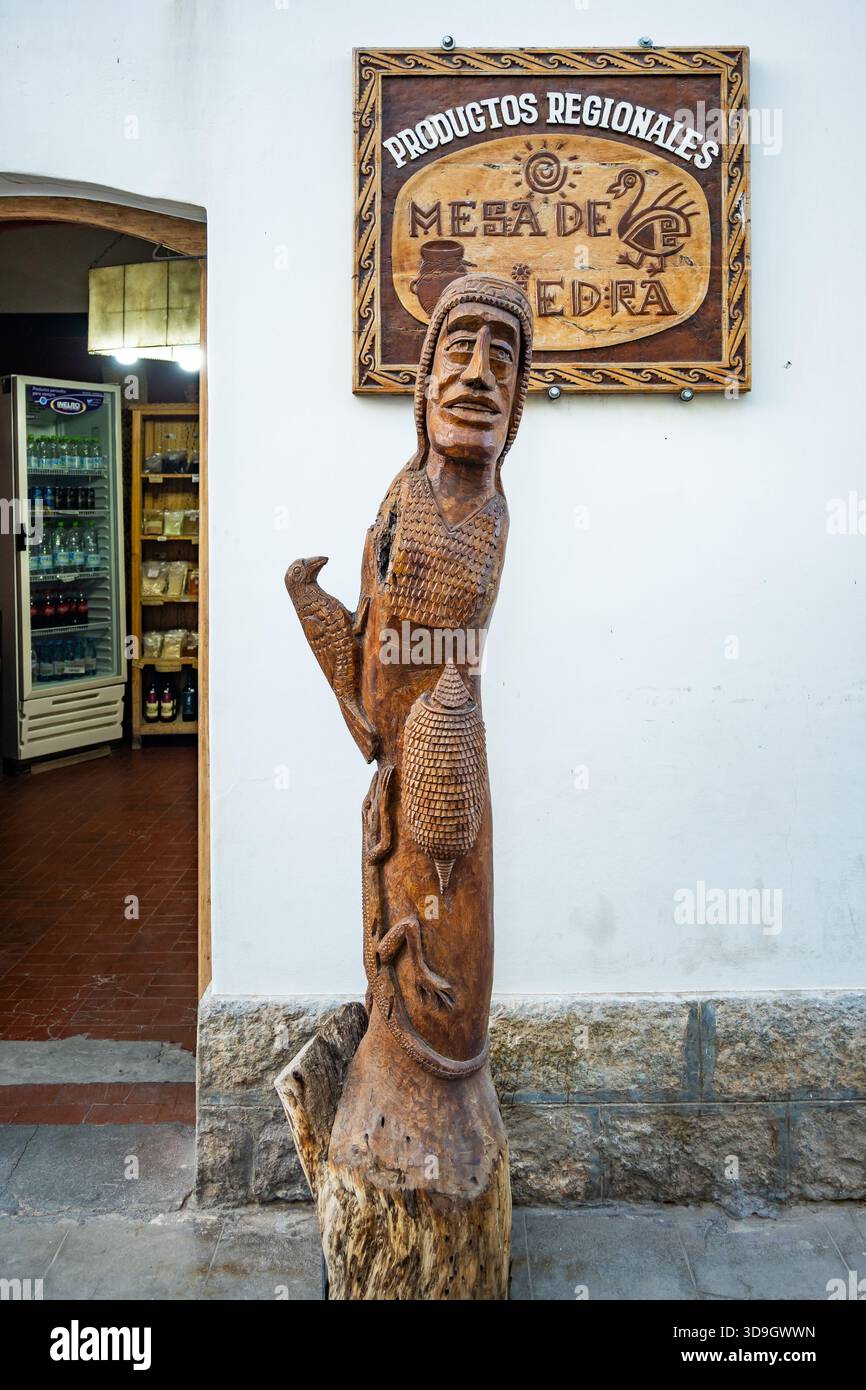 Un personnage humain sculpté dans un arbre debout devant un magasin local. Cachi, Salta, Argentine. Banque D'Images