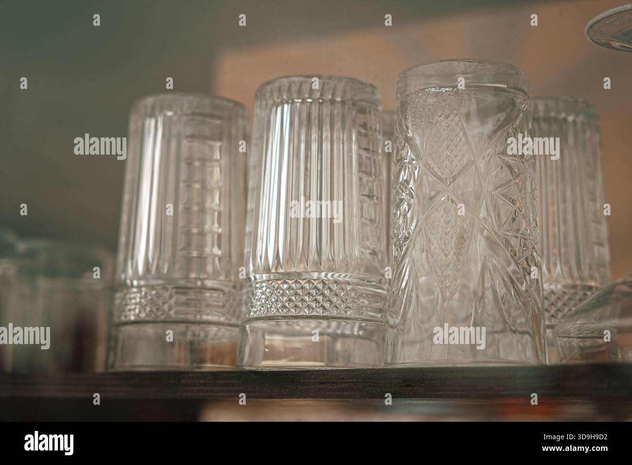 Verres à boire empilés dans un ordre géométrique dans un coffret en verre à l'extérieur d'un restaurant Banque D'Images