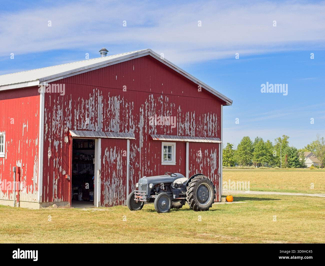 Tracteur agricole vintage debout devant la grange rouge rustique à carter Historic Farm, une propriété de conservation de la nature à Bowling Green Ohio Banque D'Images
