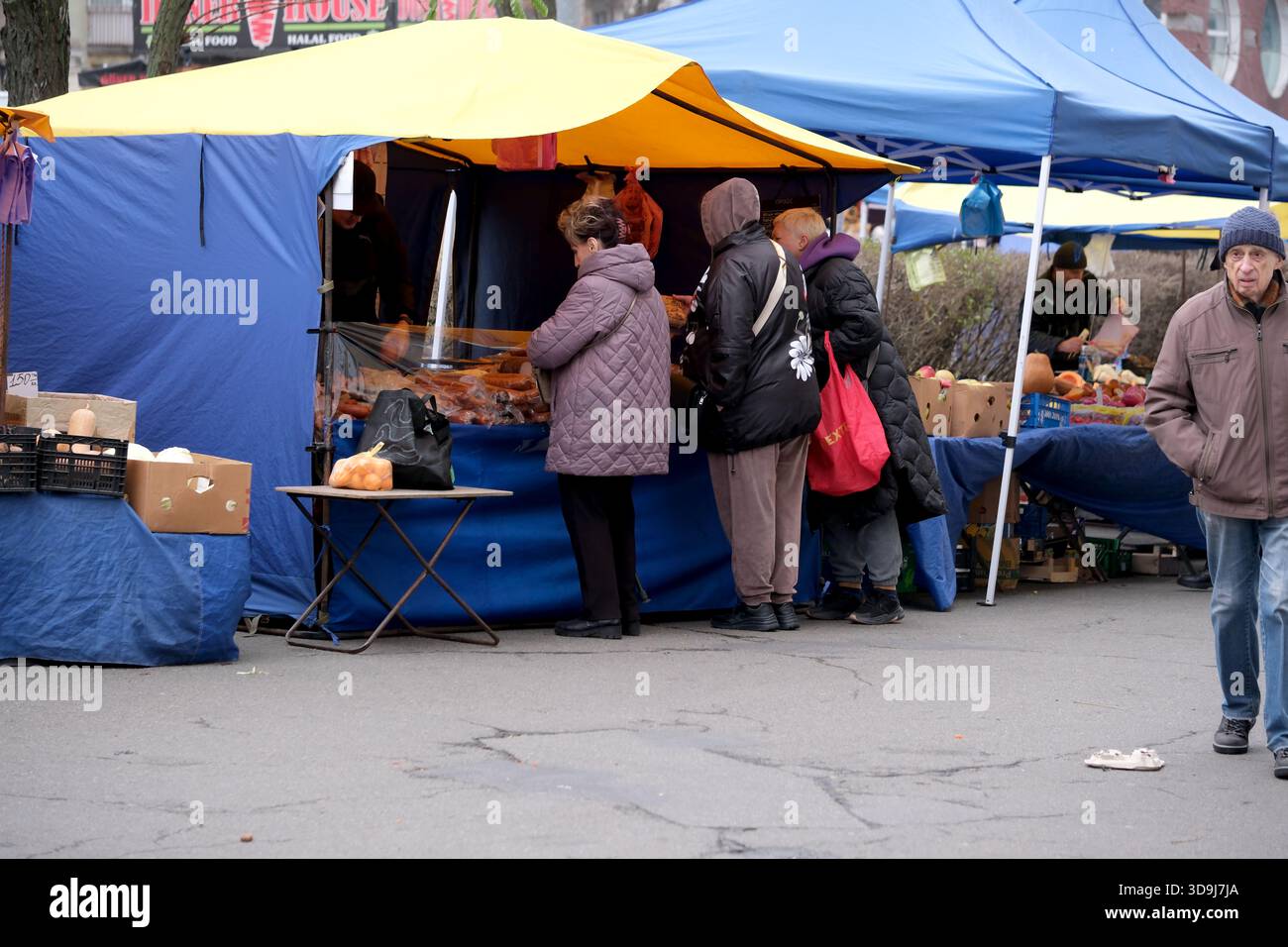 Les visiteurs parcourent les étals colorés du marché remplis de produits frais et de produits locaux. Kiev, Ukraine. 5 décembre 2025. Banque D'Images