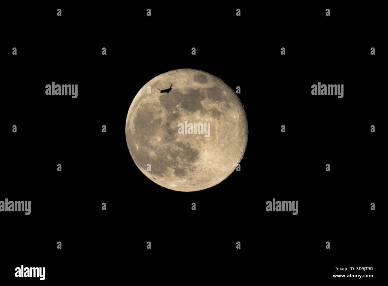 Lisbonne, Portugal. 05th Dec, 2025. Un avion vole près de la silhouette de la lune, qui s'élève au-dessus du ciel de Lisbonne. Mère nature a décidé d'afficher la dernière super lune de l'année, connue sous le nom de super lune froide. À sa phase complète et coïncidant avec son périgée, le satellite était situé à seulement 356 000 kilomètres de la Terre, apparaissant jusqu'à 14% plus grand et 30% plus lumineux qu'une pleine lune conventionnelle. Crédit : SOPA images Limited/Alamy Live News Banque D'Images