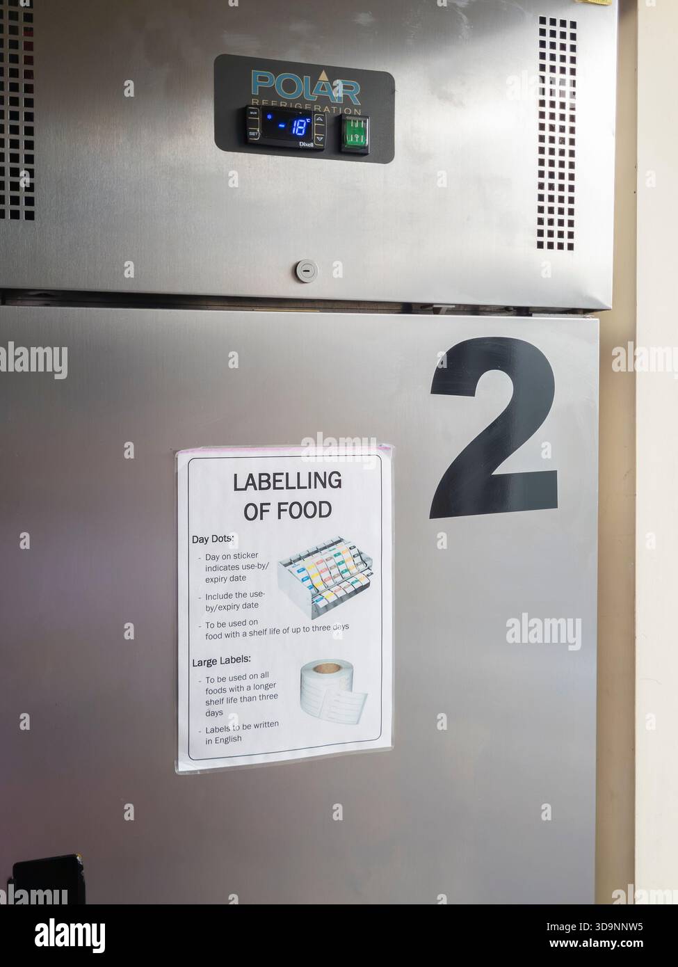 Avis sur la porte d'un réfrigérateur dans la cuisine commerciale d'un restaurant indiquant les règles d'étiquetage des aliments / d'hygiène à suivre pour la loi de 1990 sur la sécurité alimentaire, Angleterre Banque D'Images