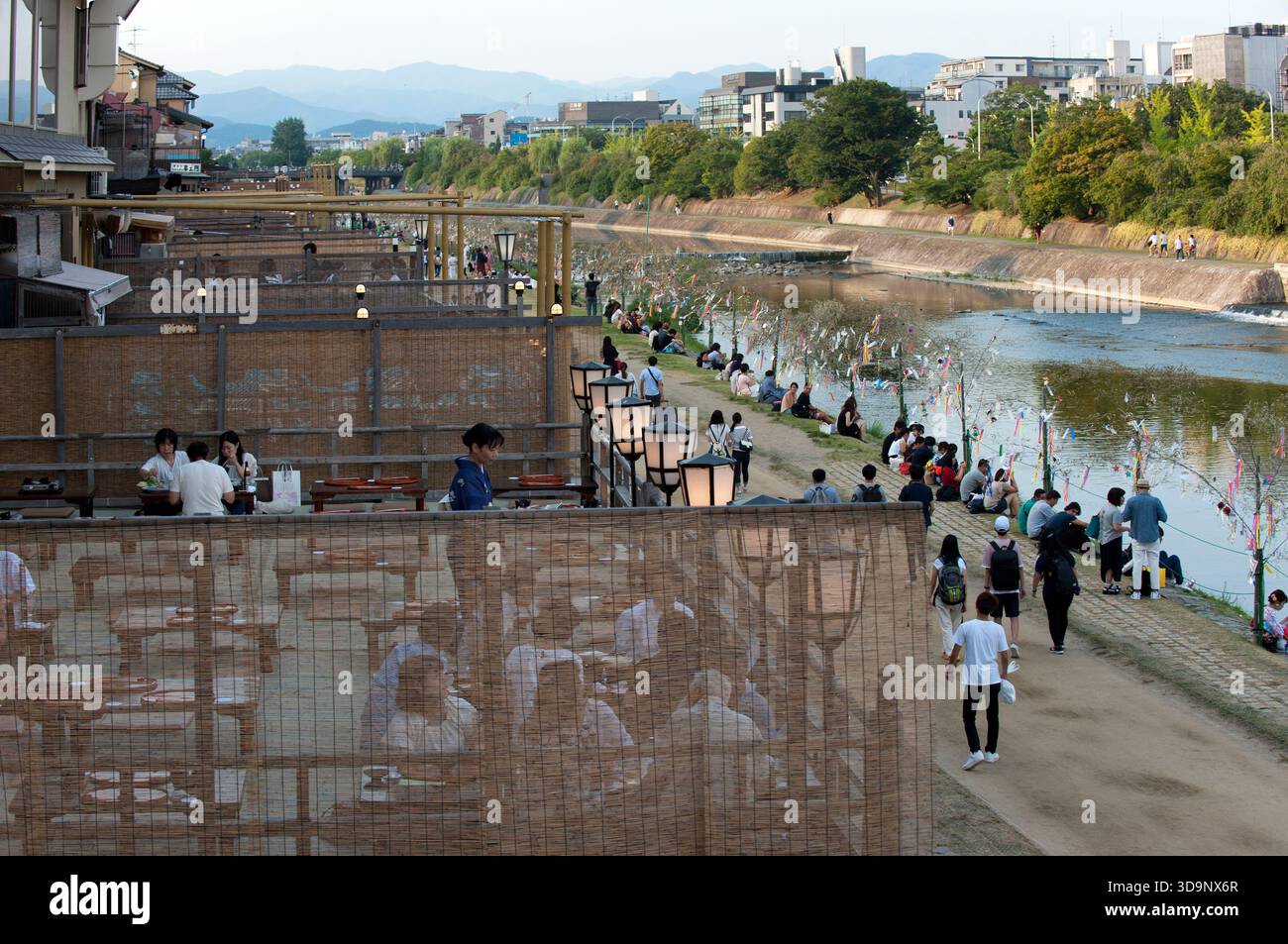 Les terrasses de restauration « kawayuka » (川床) situées en bordure de rivière offrent une brise fraîche naturelle dans les chaudes soirées estivales le long de la rivière Kamo à Kyoto, au Japon. Banque D'Images