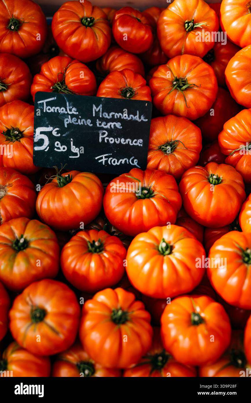Un plateau en bois de tomates mûres 'Marmande' (beefsteak ou solanum lycopersicum) avec un signe de marché manuscrit, Provence, France Banque D'Images