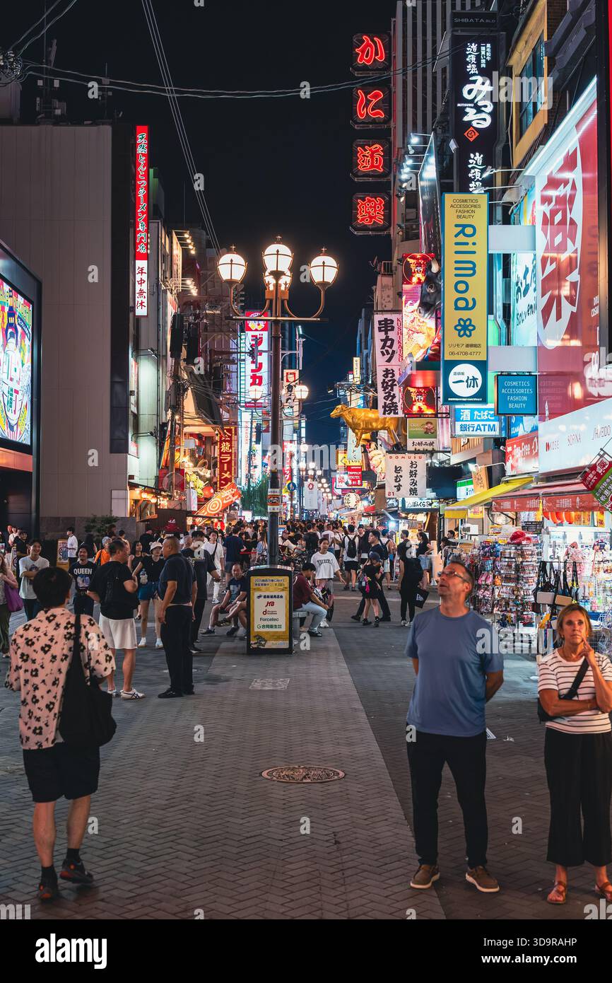 Le quartier emblématique de Dotonbori à Osaka s'anime la nuit, avec des panneaux d'affichage imposants illuminant la rue en contrebas. Banque D'Images