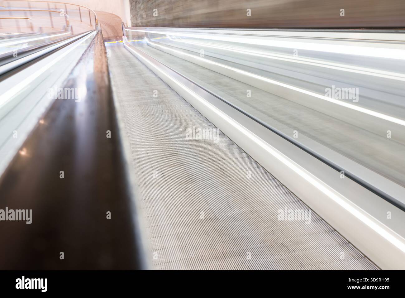 Une vue dynamique d'une passerelle mobile dans un cadre architectural moderne, mettant en valeur les lignes épurées et le flou de mouvement, mettant l'accent sur la vitesse et le mouvement. Banque D'Images
