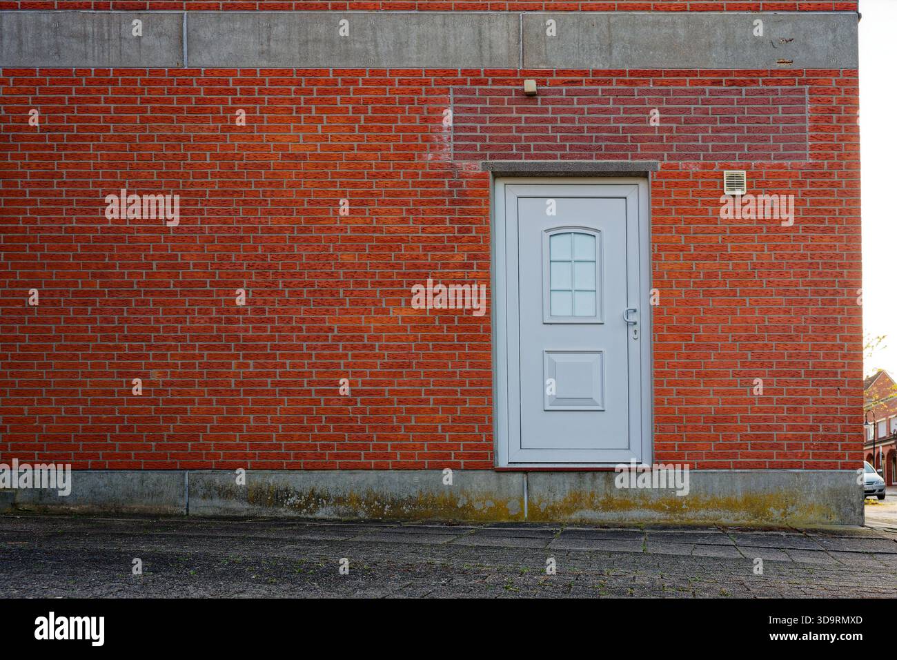 Bâtiment en briques rouges se dresse sur des blocs de béton, tandis que la porte se trouve étrangement haut au-dessus du sol sans marches. Le seuil relevé rend l'accès impossible, Banque D'Images