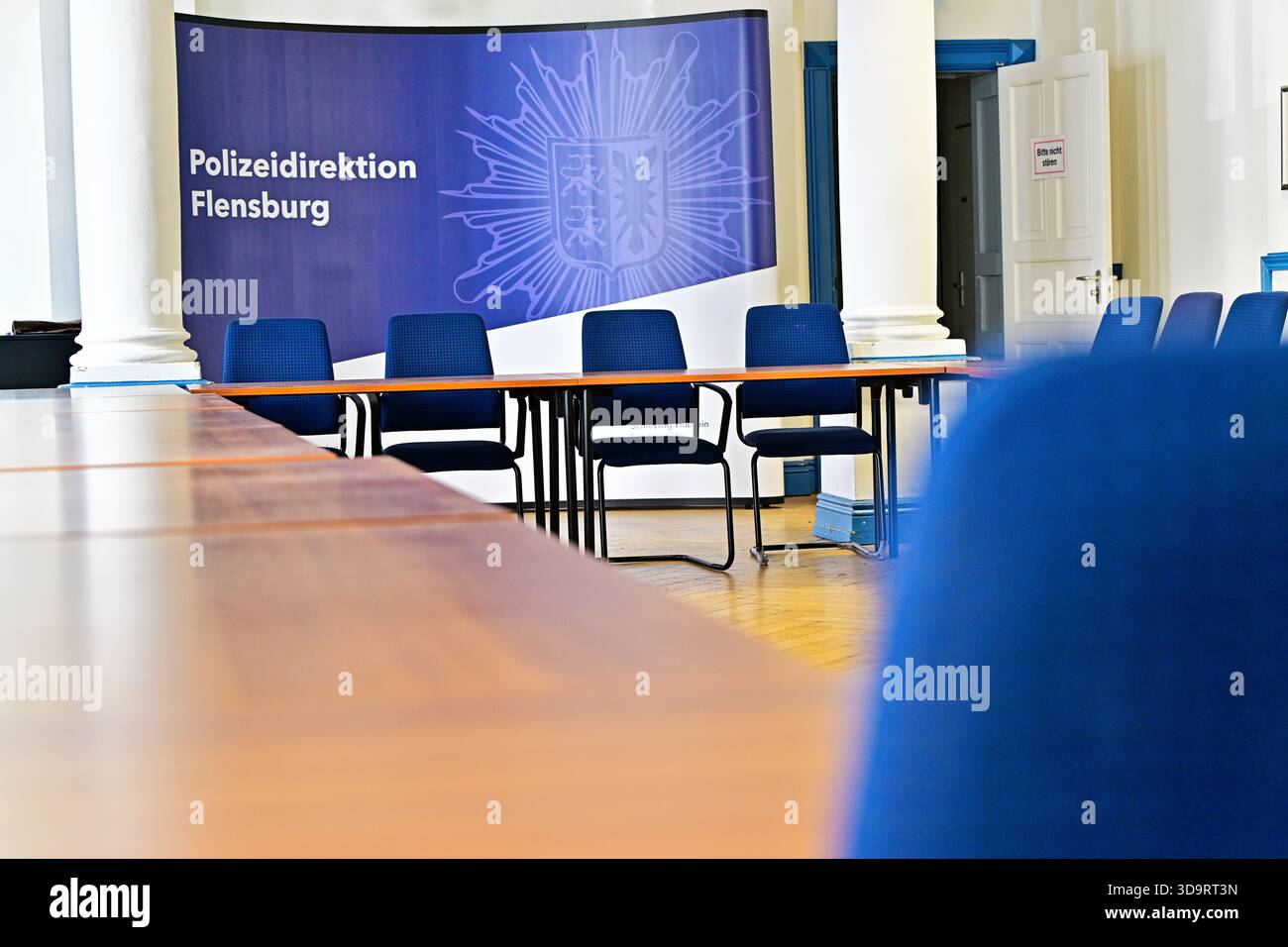 Au Département de police Flensburg, les chaises bleues font face à de longues tables, les colonnes blanches gardent les lignes propres, le panneau nomme Polizei Direktion Flensburg police Dep Banque D'Images