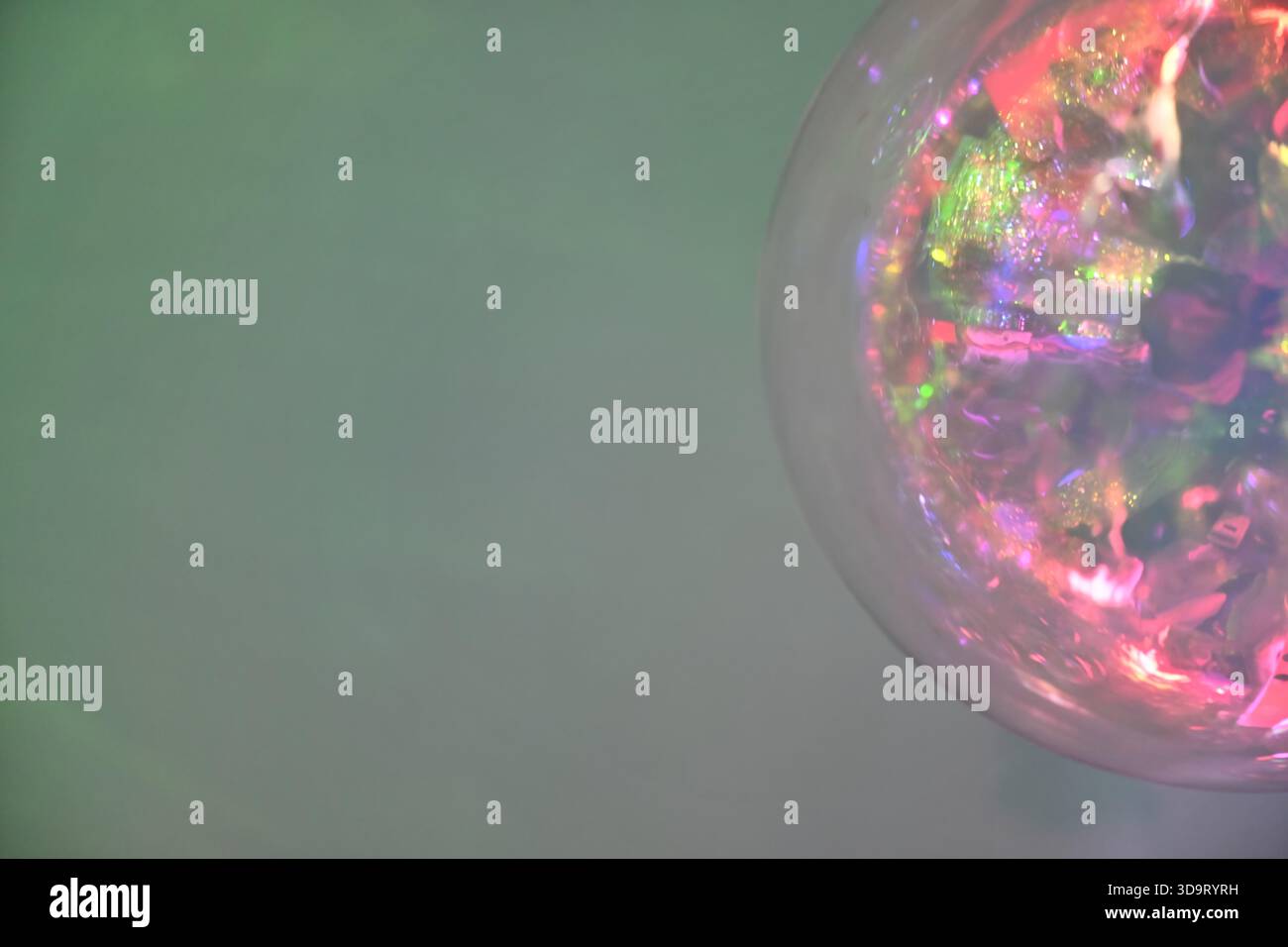 Gros plan d'un orbe coloré et réfléchissant avec un arrière-plan doux et flou. L'orbe affiche un mélange de couleurs éclatantes et de reflets lumineux, créant un dr. Banque D'Images
