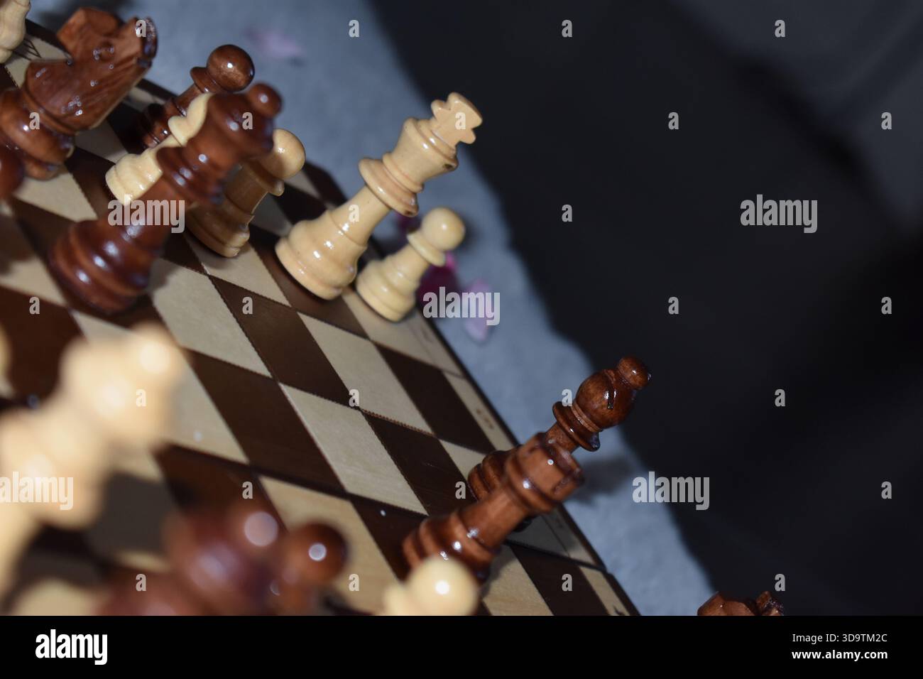 Pièces d'échecs noires et blanches sur un échiquier en bois Banque D'Images