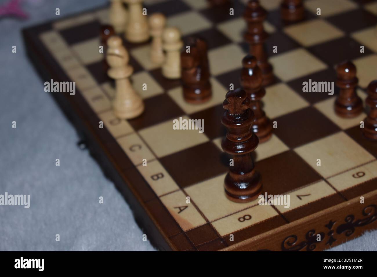 Pièces d'échecs noires et blanches sur un échiquier en bois Banque D'Images