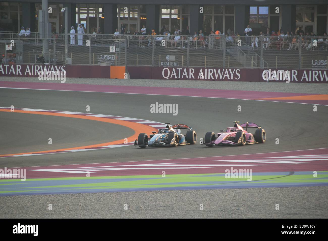 Deux voitures de course s'affrontent étroitement sur la piste lors du Grand Prix du Qatar de formule 1 2025 au circuit international de Lusail à Doha. Banque D'Images