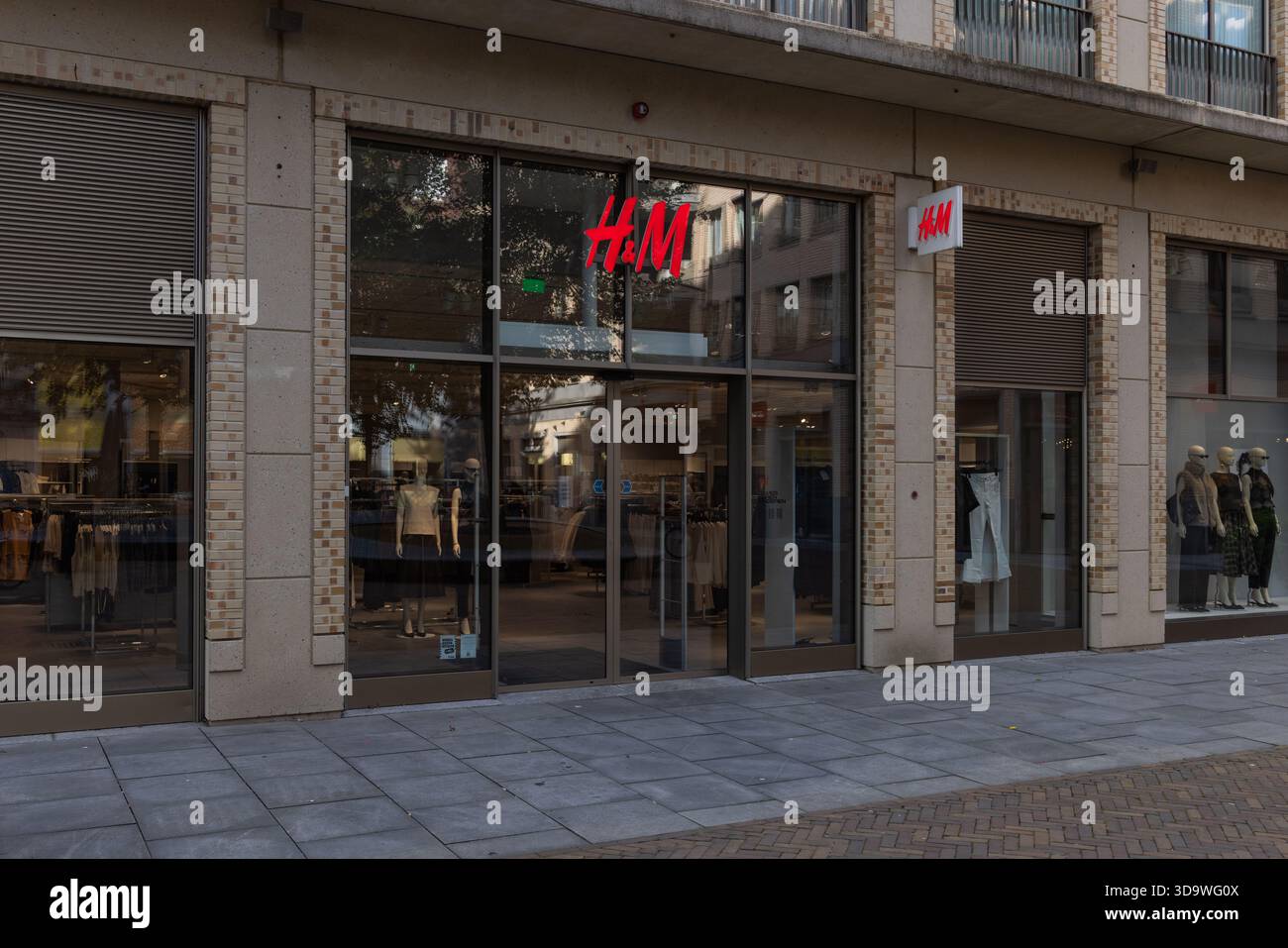 Entrée principale d'un magasin de vêtements H&M avec fenêtres en verre, mannequins et logo rouge sur une rue commerçante dans une ville néerlandaise. Utrecht, pays-Bas. 25 se Banque D'Images
