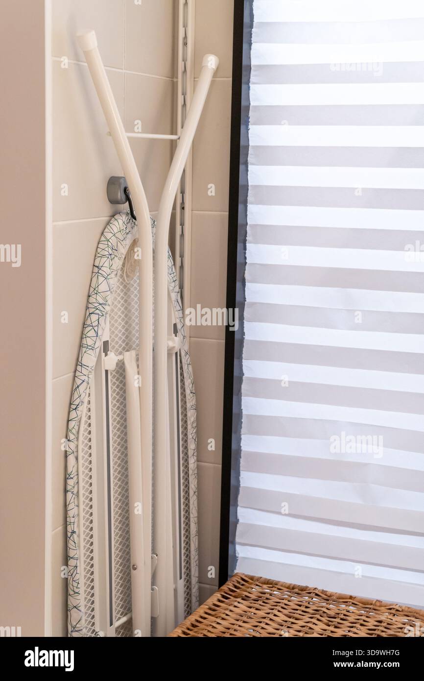 Planche à repasser pliée stockée dans une petite buanderie avec espace de copie Banque D'Images