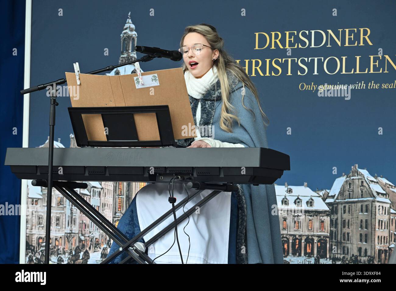 GER Sachsen Dresde 30. Stollenfest vor derm Kulturpalast mit Umzug durch die Dresdner Innenstadt verfolgt von 60 000 Besuchern Dresdner und Touristen - der Stollen wurde mit dem Riesenstollenmesser durch das Stollenmädchen Johanna Worm und Bäckermeister Reiner Israel angeschnitten und dann Portionsweise für 10 Euro je 500 g verkauft - hier das Stollenmädchen beim front Singen06.112.25 0612251025 *** le festival de Dollenstollenden 60 000 Dollenden et les visiteurs de la ville de Dollenville de Dollenden 30 couper avec le stollen géant Banque D'Images