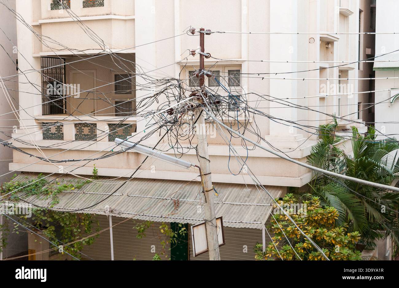 Câbles électriques sur un pilier électrique le long d'une rue à Puttaparthi, Andhra Pradesh, Inde Banque D'Images