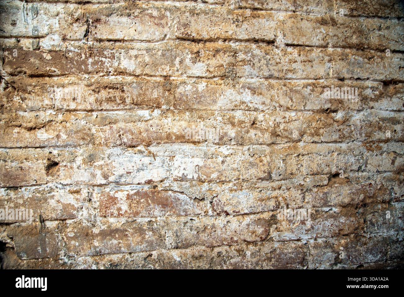 Texture murale en brique vieillie avec usure naturelle et tons terreux. Vieille surface de briques avec des couches détériorées et un aspect rustique et robuste. Banque D'Images