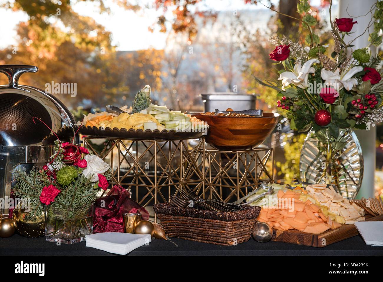 Table de buffet des fêtes avec assortiment de fromages, fruits et fleurs. Banque D'Images