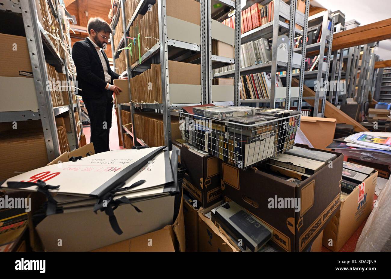 08 décembre 2025, Thuringe, Eisenach : Richard Limbert, archiviste musical, se tient au milieu de la collection Benny Goodman. Fondée en 1999, l'archive musicale Lippmann Rau à Eisenach recueille et étudie l'histoire de la musique populaire du XXe siècle en Allemagne de l'est et de l'Ouest. En plus des documents d'archives classiques, les collections comprennent également des enregistrements sonores, des livres, des magazines, des photographies, des livrets de programmes et des affiches de concerts. Les archives portent le nom des organisateurs de concerts Horst Lippmann et Fritz Rau, dont elles abritent les domaines. Les archives musicales Lippmann et Rau sont en cours de réalisation Banque D'Images