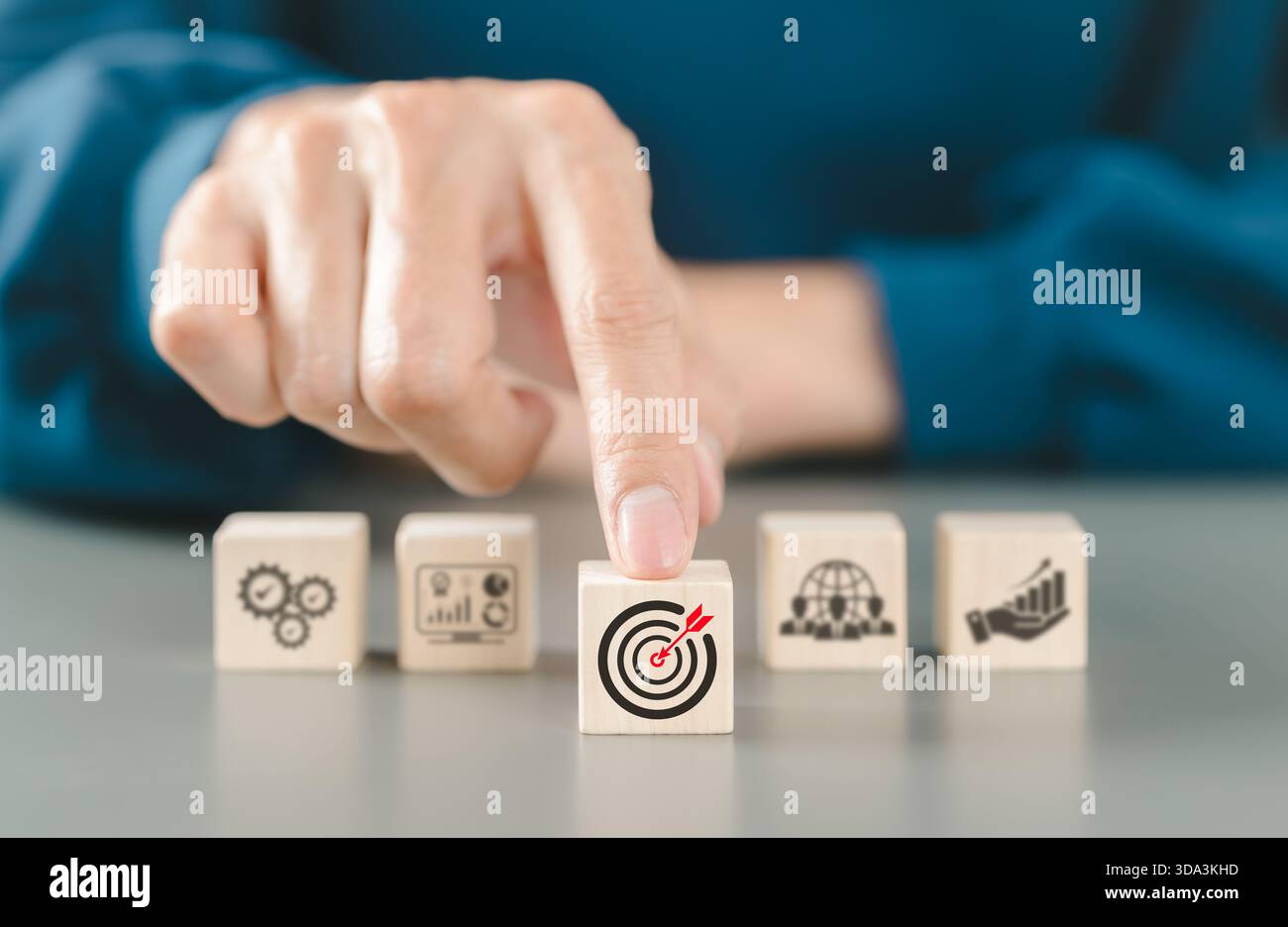 Concept de croissance de l'entreprise. Définition de l'objectif cible de l'entreprise, la personne pointe sur un bloc de bois avec une icône de fléchette rouge objectifs d'entreprise. travail d'équipe, Banque D'Images