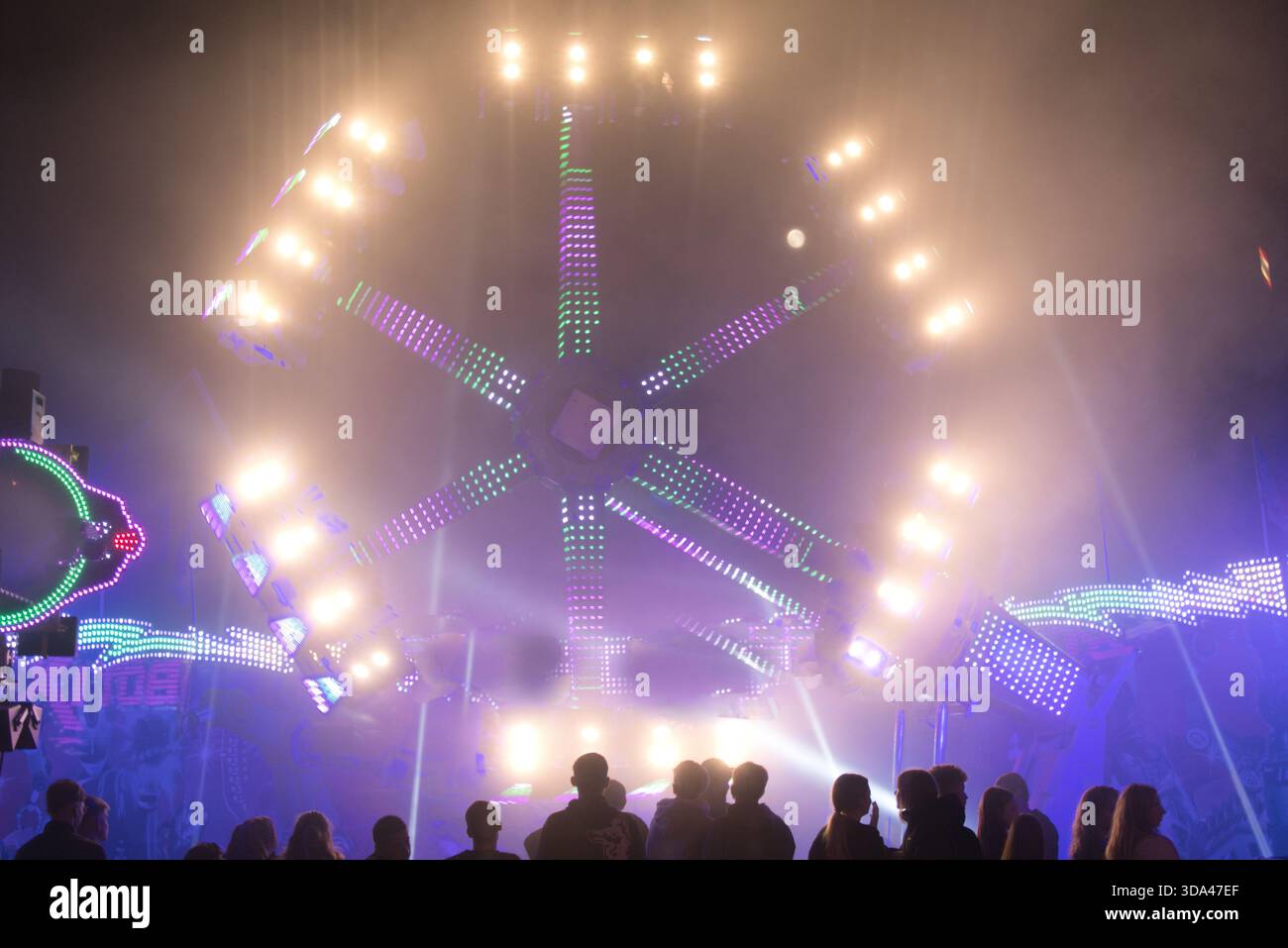 Excursion de carnaval à grande vitesse très éclairée au champ de foire nocturne Banque D'Images