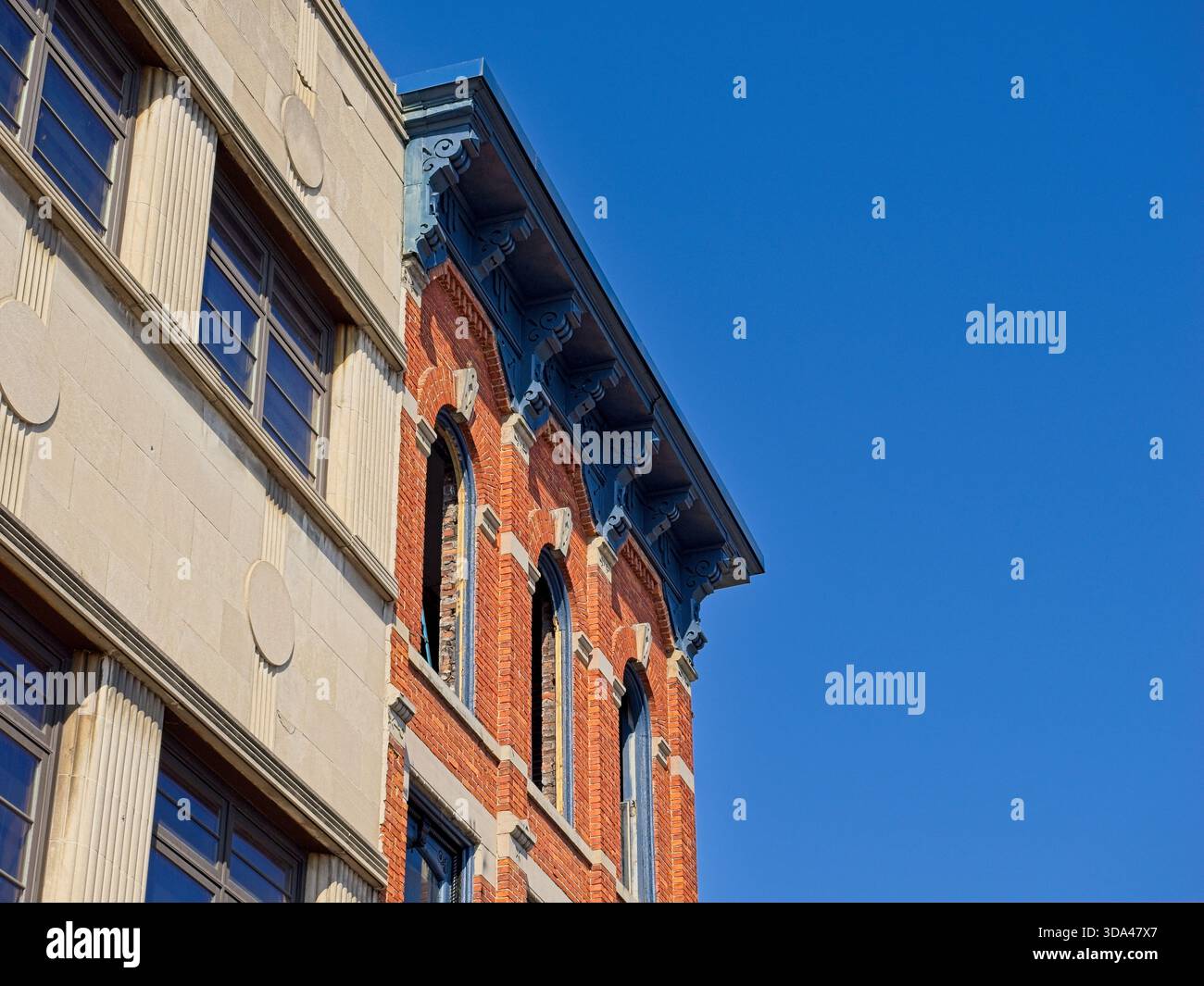 Corniche ornée sur un bâtiment en briques de la fin du XIXe siècle à côté de la façade Art déco du début du XXe siècle Banque D'Images
