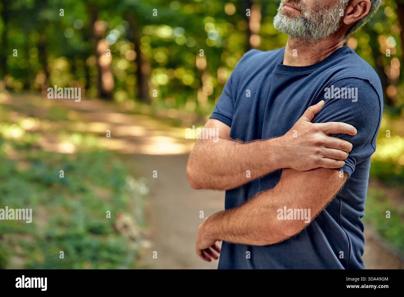 Dans une forêt tranquille, la douleur à l'épaule d'un homme reflète ses sentiments complexes sur la guérison, la promotion de la pleine conscience et une connexion plus profonde avec la nature, enc Banque D'Images