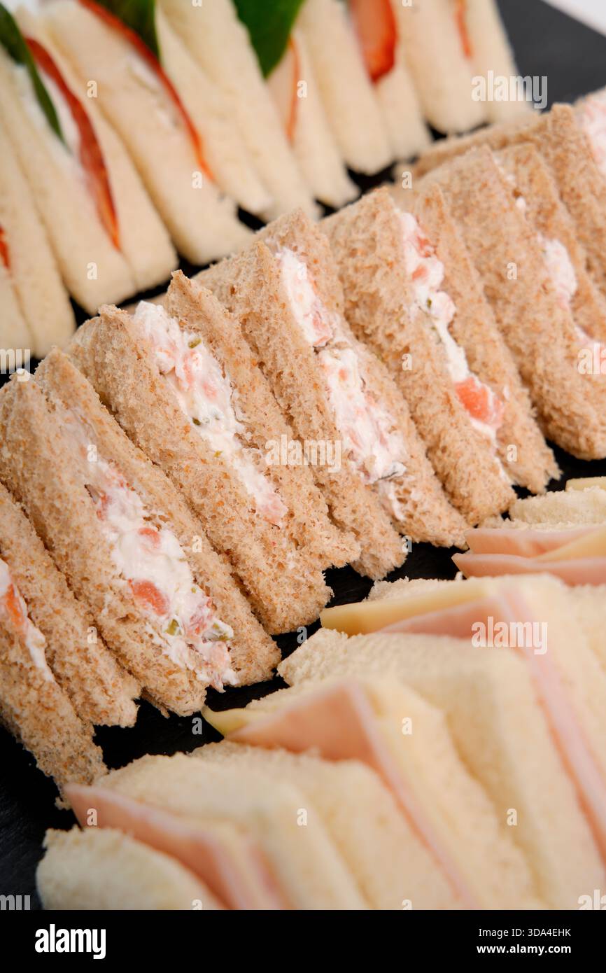 Rangées de délicieux sandwichs aux doigts avec diverses garnitures arrangées pour une fête Banque D'Images