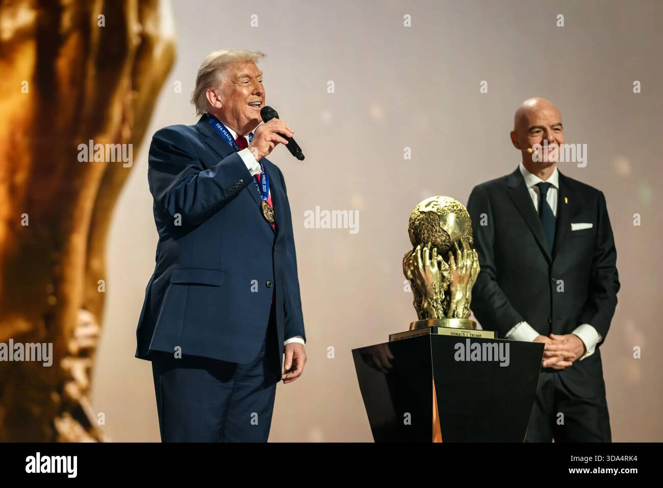 Le président Donald Trump s’exprime sur scène aux côtés du président de la FIFA Gianni Infantino lors du tirage au sort de la finale de la Coupe du monde de la FIFA 2026 au Kennedy Center à Washington, D.C. le 5 décembre 2025. Image reproduite avec l'aimable autorisation de la Maison Blanche. Banque D'Images