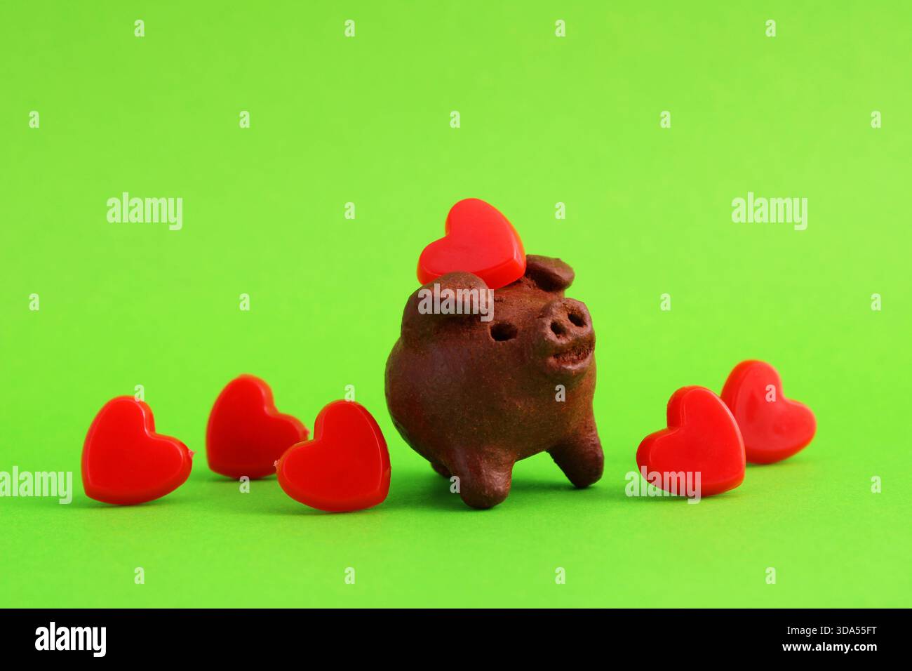 Le cochon d'argile recueille les cœurs rouges Banque D'Images