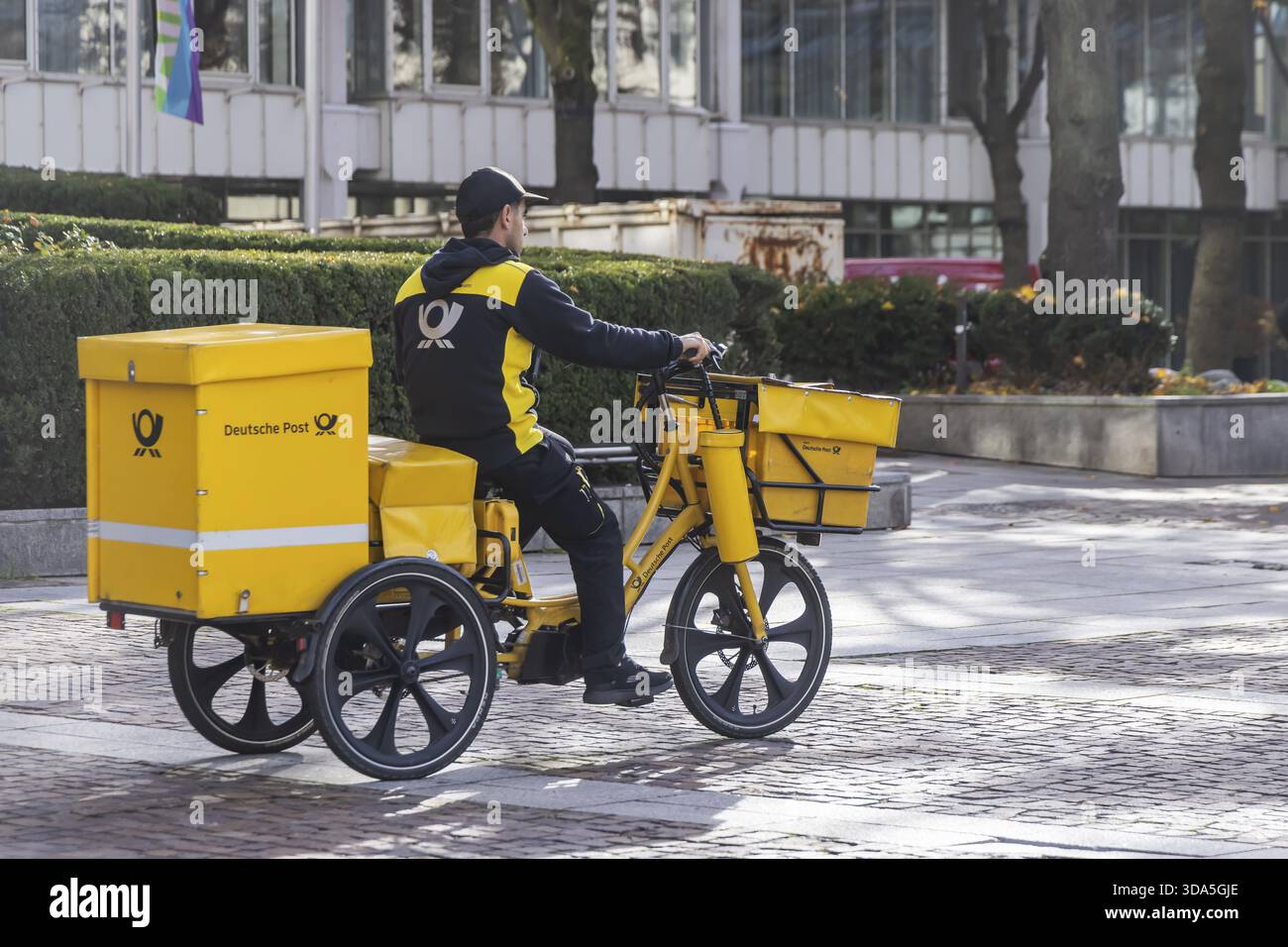 Deutsche Post mailmen sur un vélo à travers la ville. Stuttgart, Bade-Wuerttemberg, Allemagne Banque D'Images