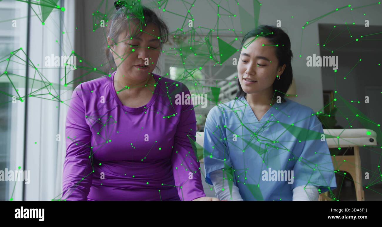 Patient assis en violet et clinicien en gommage bleu sur la table de la clinique, montrant le réseau RA vert Banque D'Images