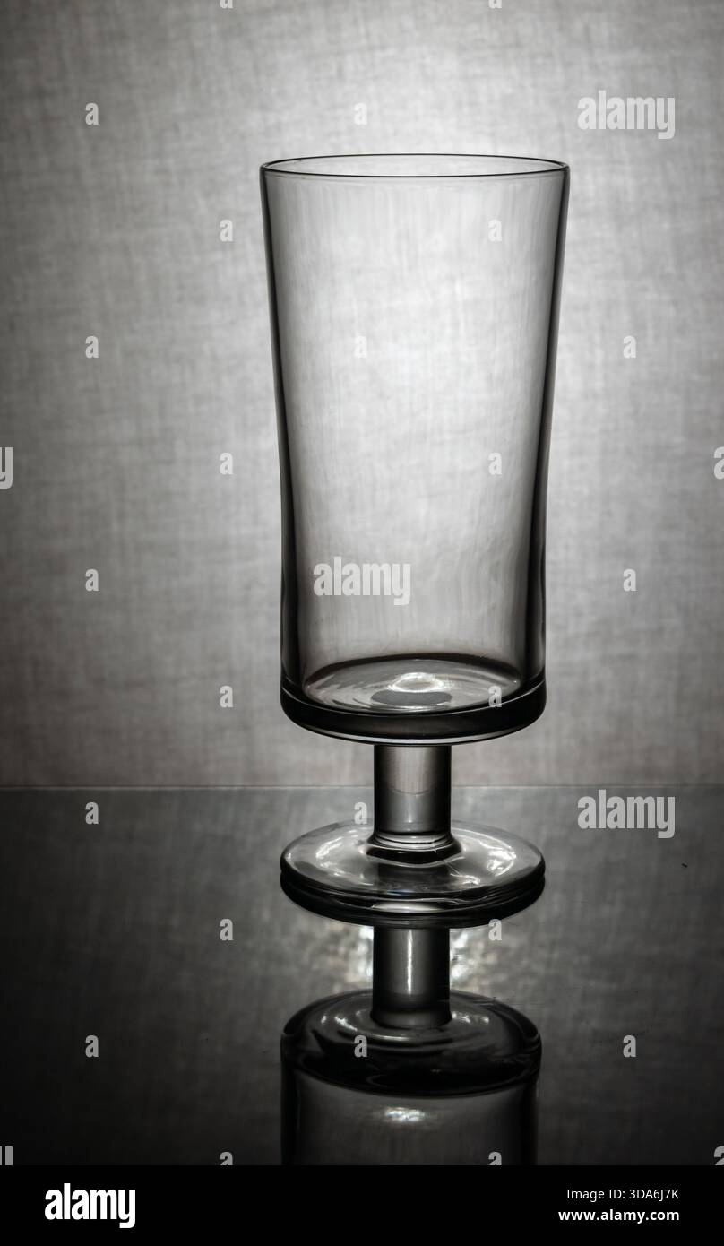 verre à bière vide avec réflexion sur fond gris texturé Banque D'Images