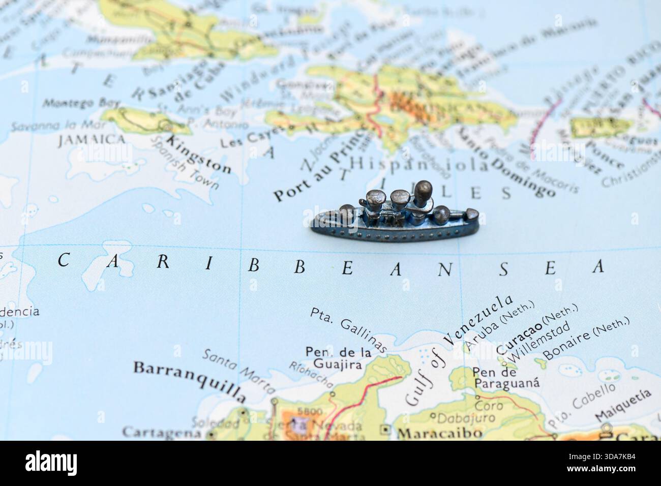 Un cuirassé jouet repose sur une carte de la mer des Caraïbes, symbolisant l'activité navale ou la navigation près de la Jamaïque, Cuba et Hispaniola. Banque D'Images