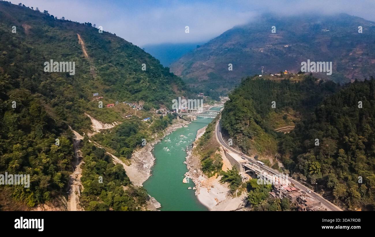 Vue aérienne de la rivière serpentine Trishuli serpentant à travers le terrain accidenté, embrassé par des montagnes verdoyantes et la sinueuse Prithvi Highway, Pok Banque D'Images